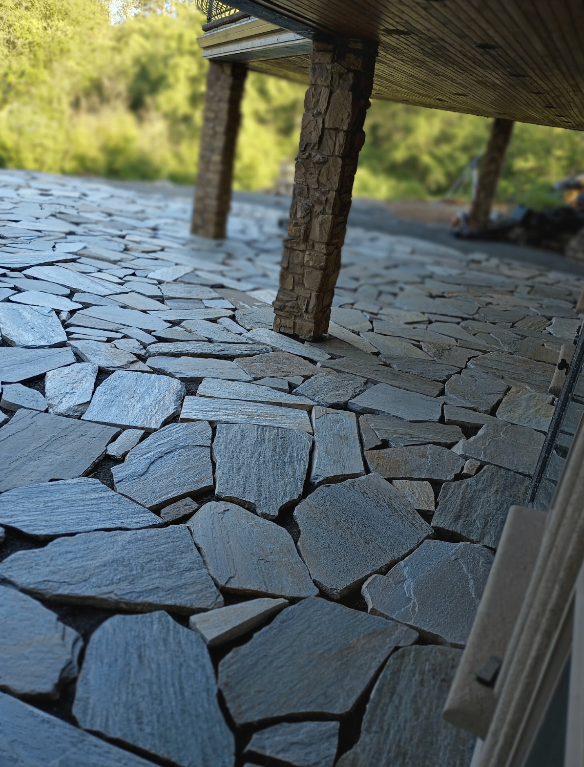 Covered outdoor living area with natural stone flooring