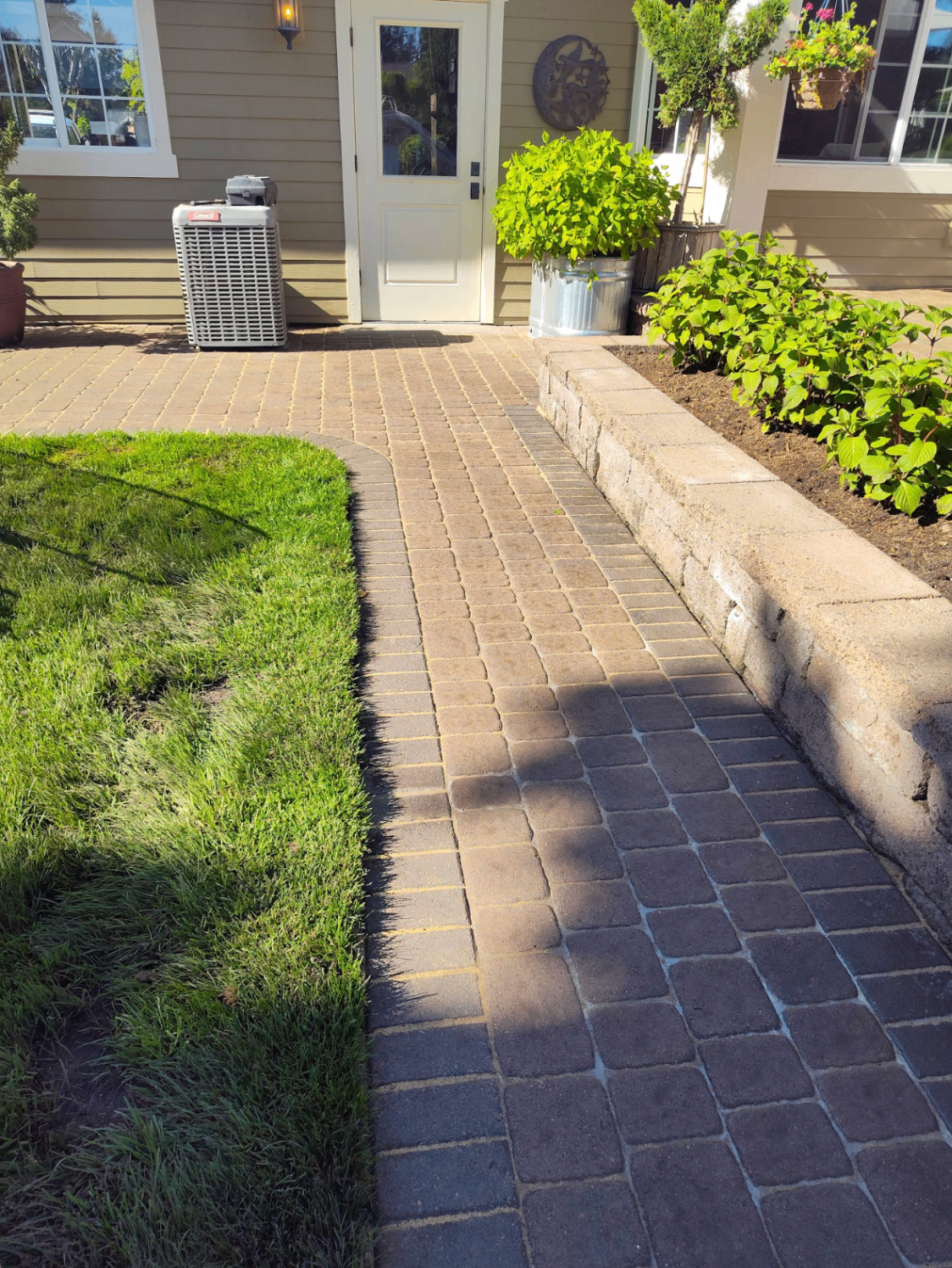 Front entry paver walkway with raised planter bed and fresh lawn edge