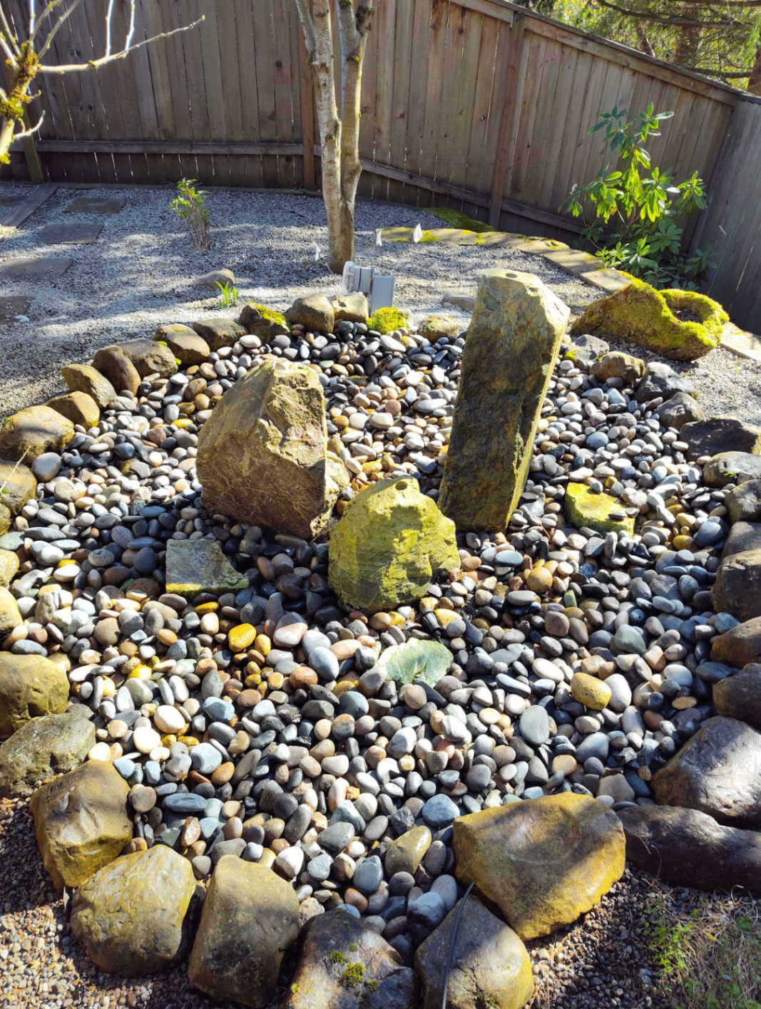 Decorative rock garden with large natural boulders and smooth river stone