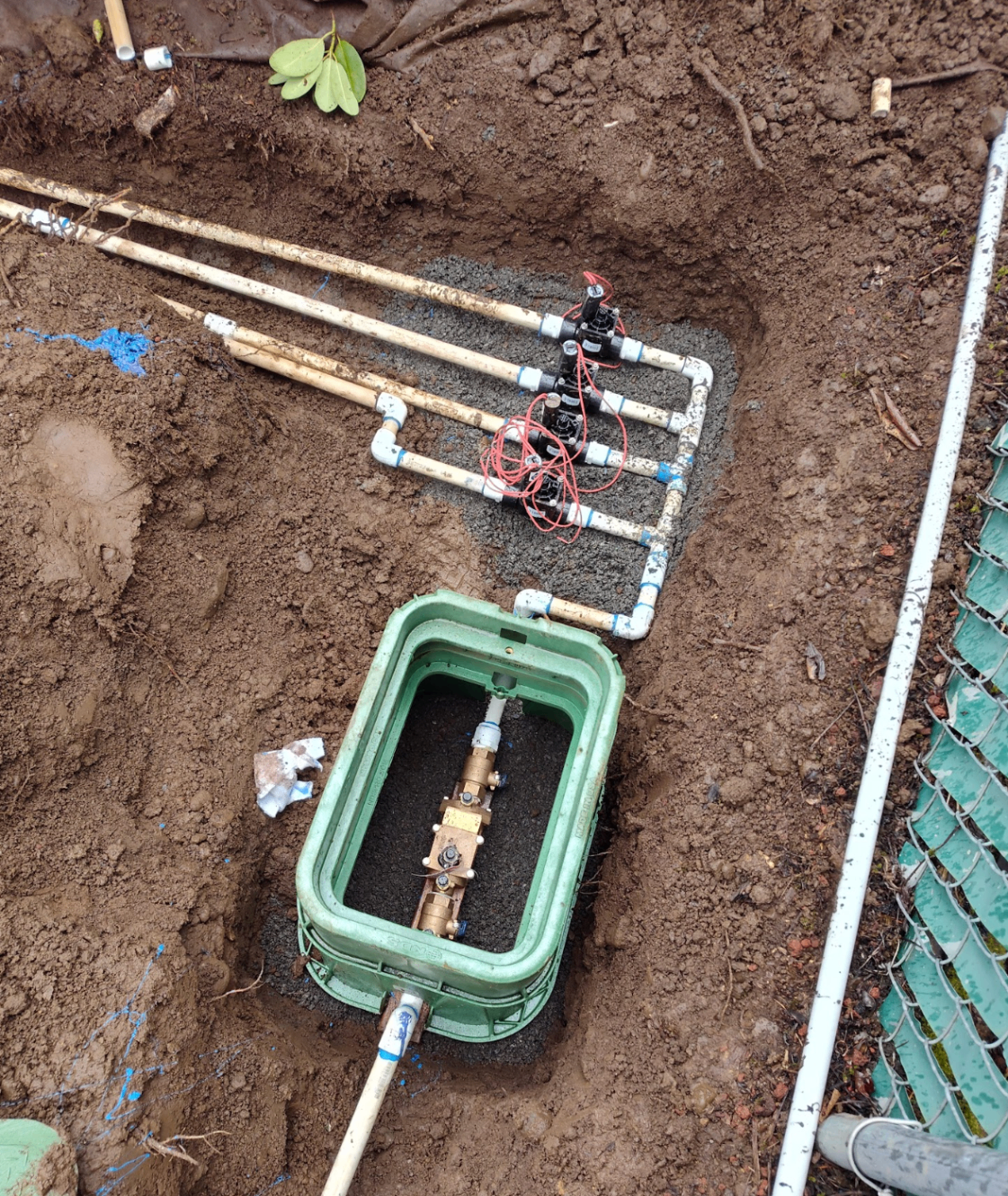 Irrigation valve box and sprinkler manifold installation in an open trench